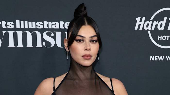 Lauren Chan poses wearing a high neck black dress and her black hair in a bun.